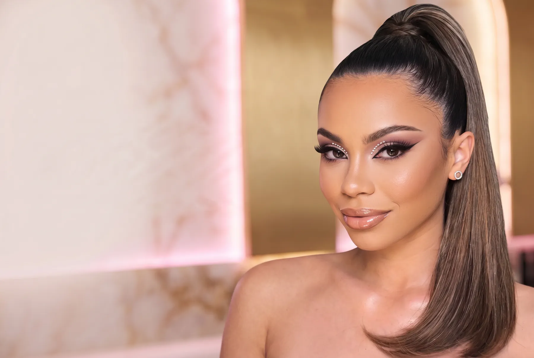 Soft bridal glam with rhinestone-lined eyes against warm marble
